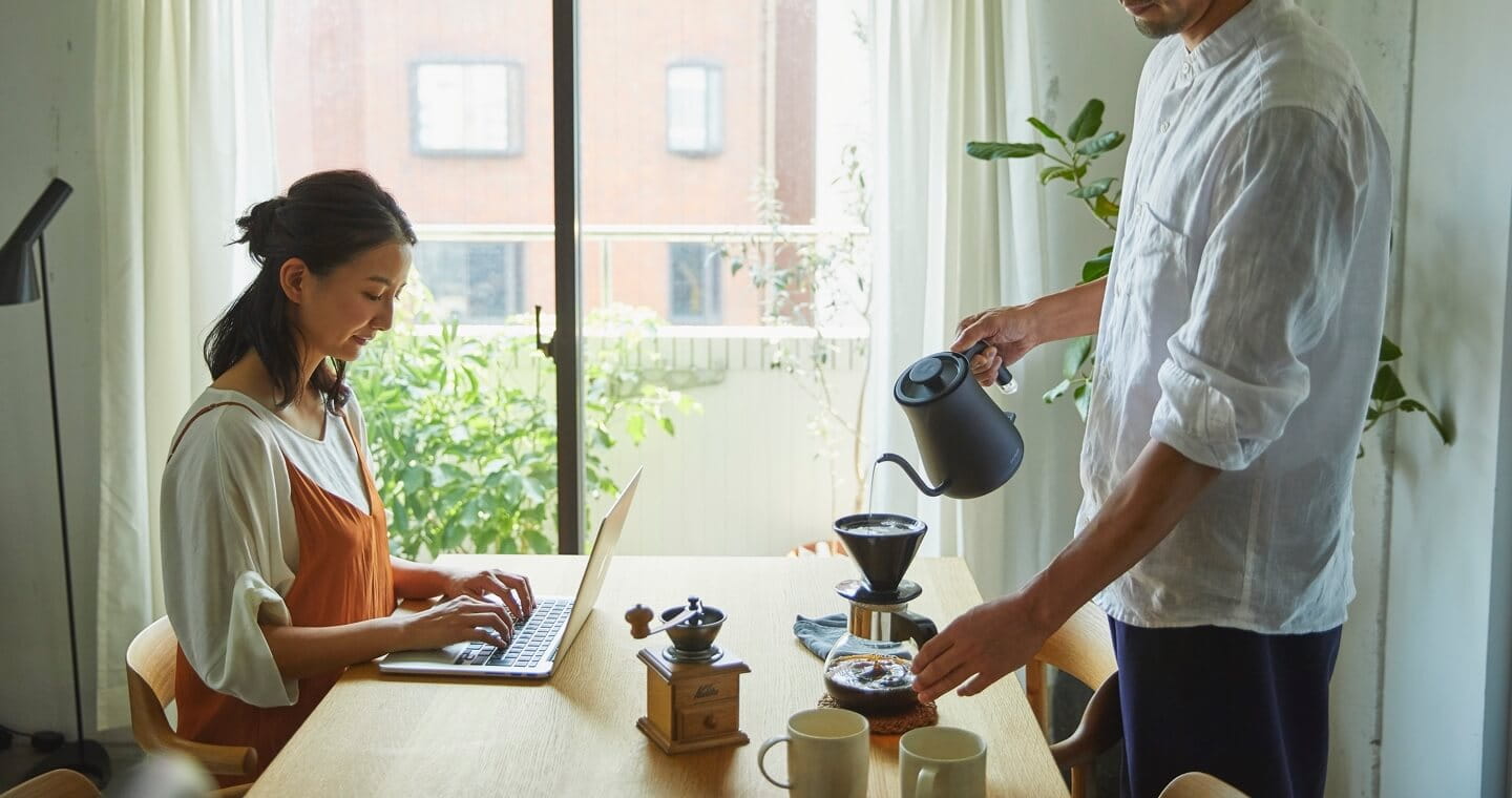 HIROMAでPC作業をする女性とコーヒーを入れる男性の写真